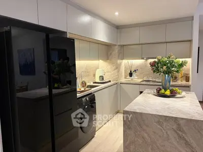 Modern kitchen with sleek cabinetry, marble island, and integrated appliances in a stylish home.