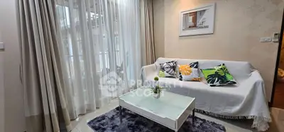 Charming living room with cozy sofa, vibrant cushions, and elegant curtains, perfect for relaxation.