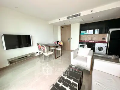 Modern living room with TV, dining set, and washing machine in a stylish apartment.