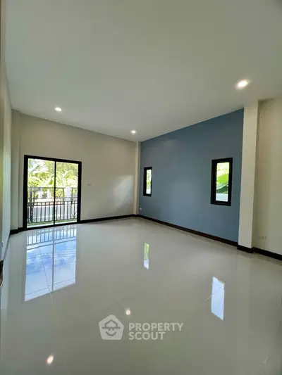 Spacious modern living room with large windows and balcony access