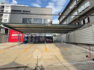 Modern commercial building with spacious parking area and sleek design.