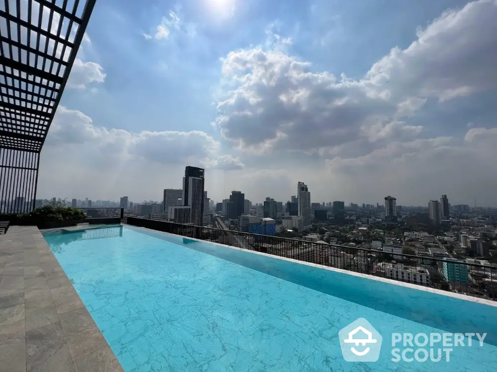 Stunning rooftop pool with panoramic city skyline view under a bright sky.