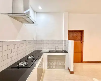 Modern kitchen with sleek gas stove and stylish backsplash in a contemporary apartment.