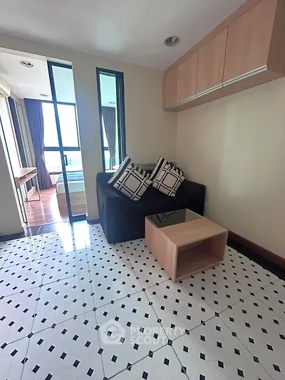 Chic living room with modern decor and stylish flooring, featuring a cozy sofa and elegant glass coffee table.