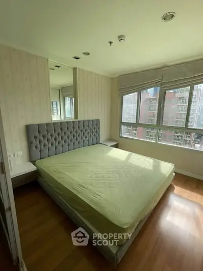 Spacious bedroom with large windows and modern decor in urban apartment