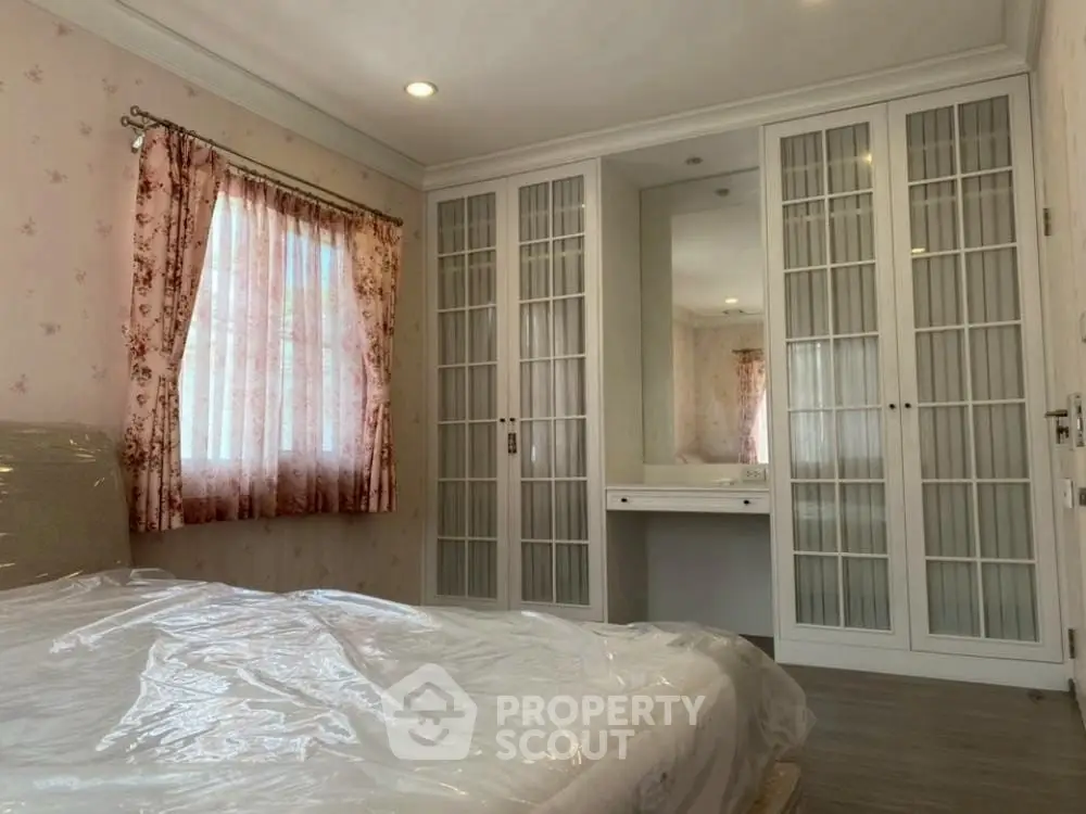 Cozy bedroom with elegant built-in wardrobe and floral curtains