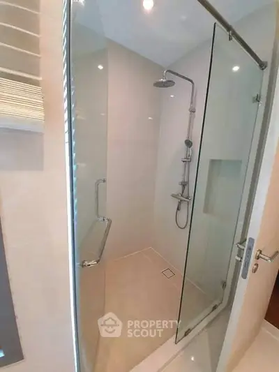 Modern bathroom with glass shower enclosure and sleek fixtures