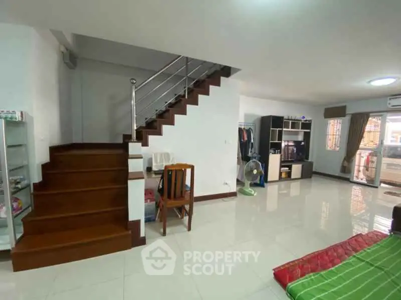 Spacious living room with modern staircase and ample natural light