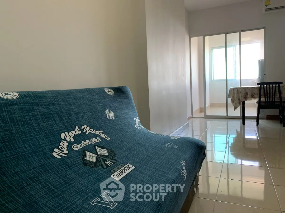 Spacious living room with stylish sofa and natural light, perfect for relaxation and entertaining.