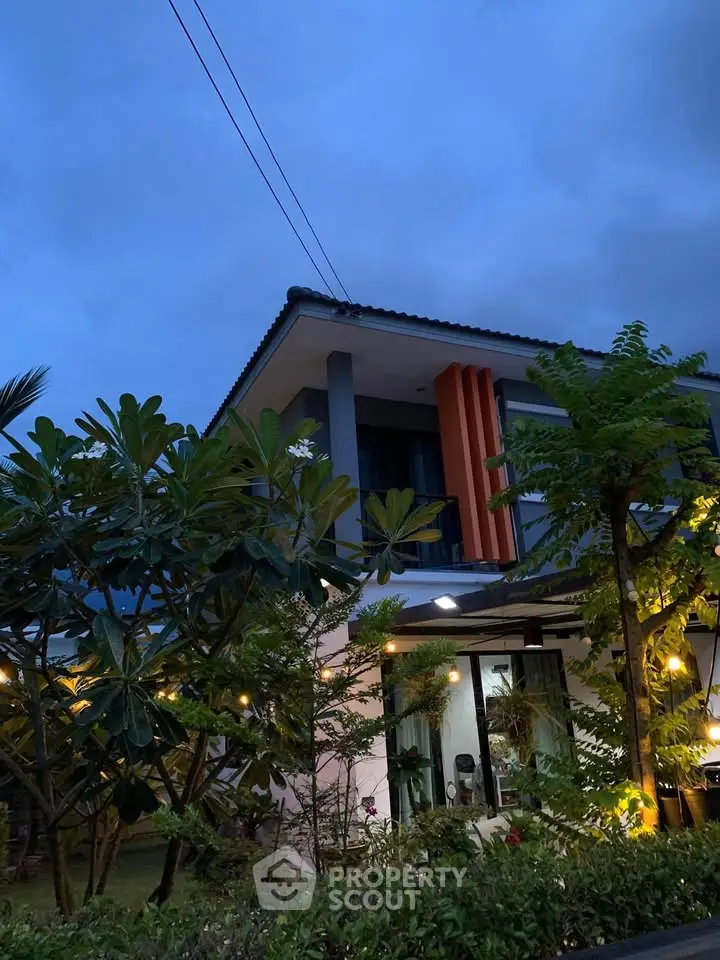 Charming two-story house with lush garden and modern facade at dusk.