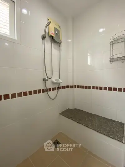Modern bathroom with shower and tiled bench, featuring sleek design and neutral tones.