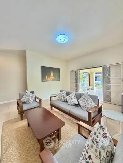 Spacious living room with elegant wooden furniture and large windows for natural light.