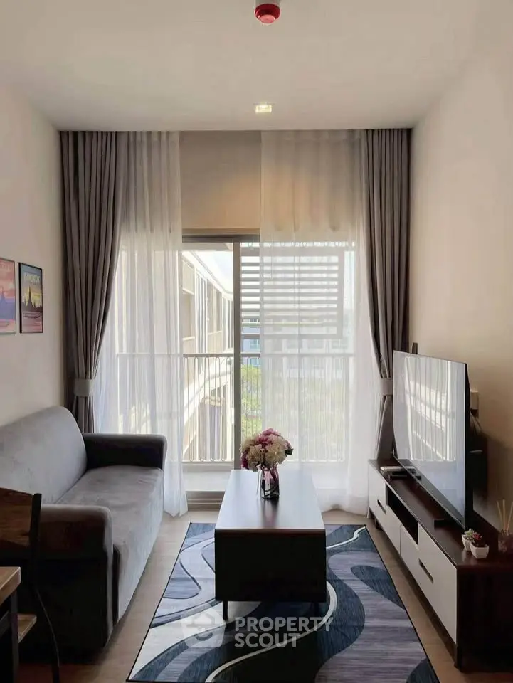 Modern living room with stylish decor and large window offering natural light.