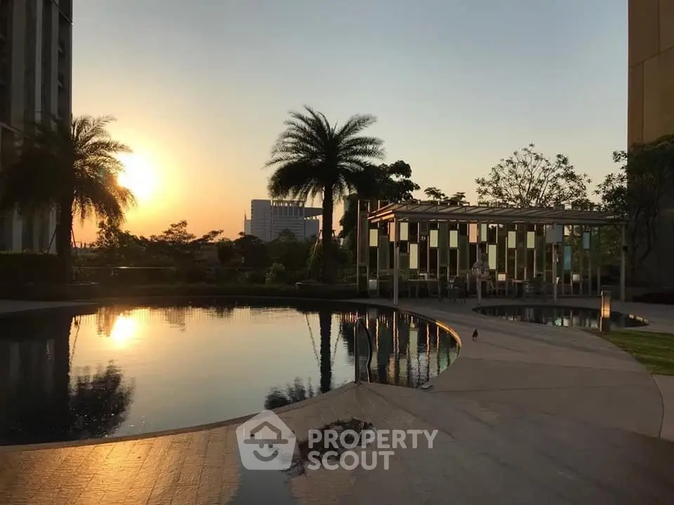 Luxurious poolside view at sunset with modern architecture and palm trees.