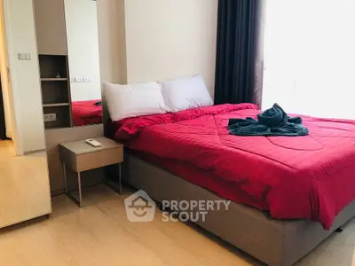Cozy bedroom with red bedding and modern decor in a stylish apartment.