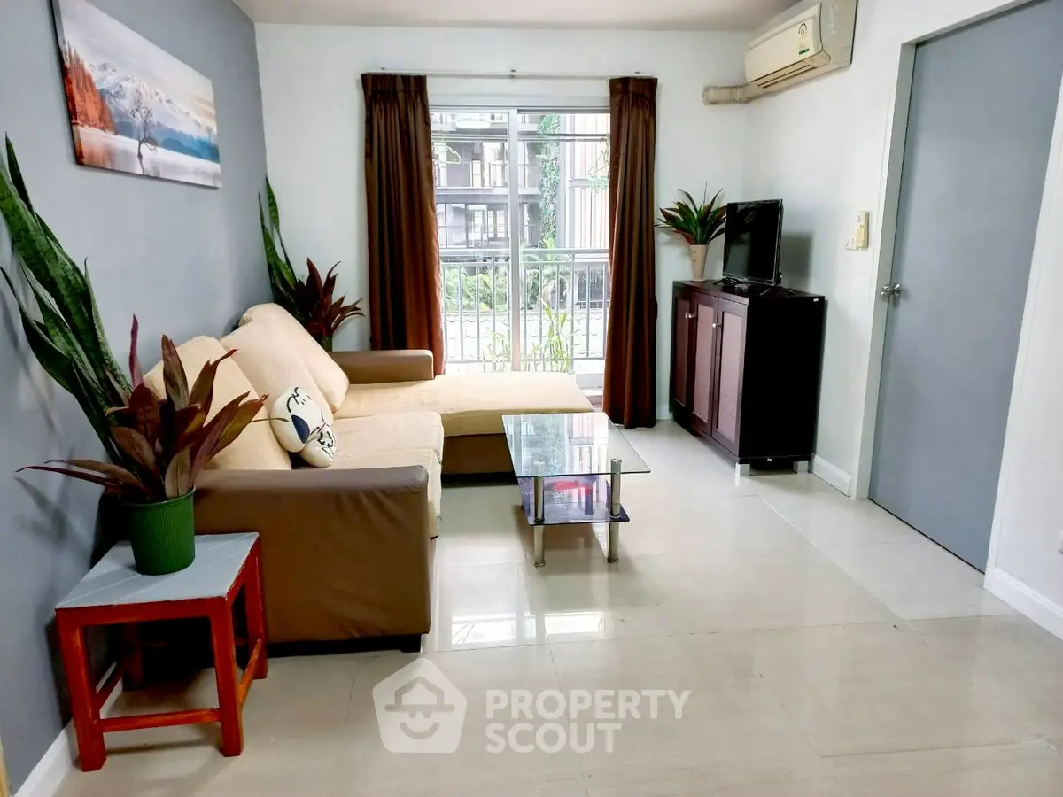Cozy living room with modern decor and natural light, featuring a comfortable sofa and sleek TV stand.