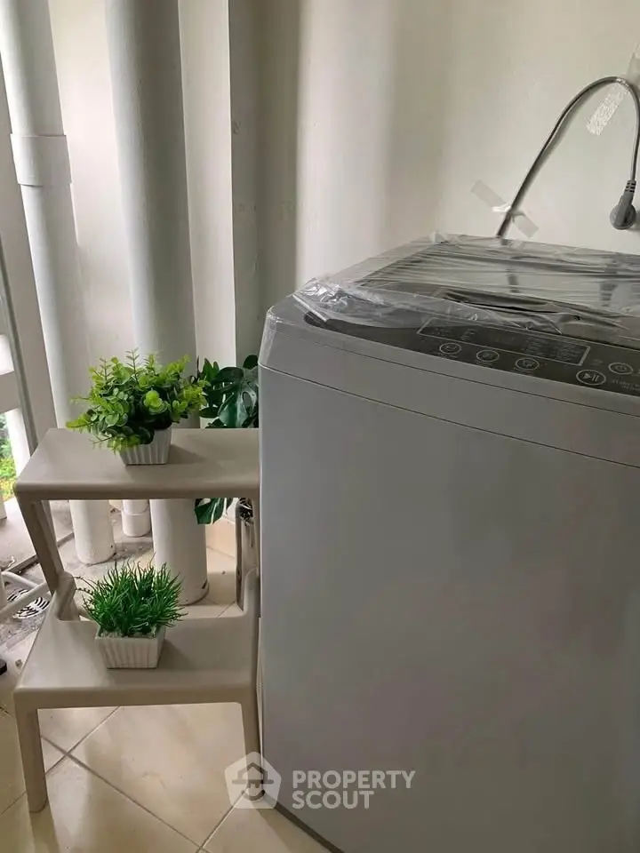 Modern laundry area with washing machine and decorative plants