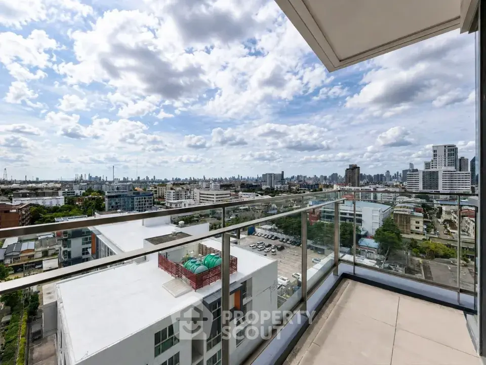 Stunning cityscape view from a modern balcony with glass railing, perfect for urban living.