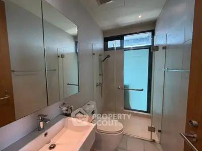 Modern bathroom with glass shower and sleek fixtures in a contemporary home.