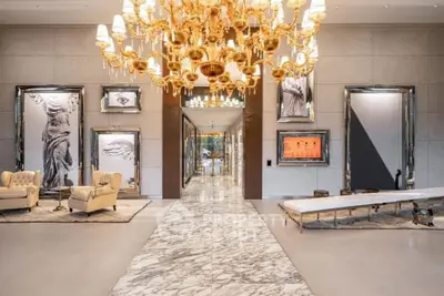 Luxurious lobby with marble flooring and grand chandelier in upscale building.