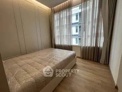 Modern bedroom with large window and elegant curtains in a stylish apartment.