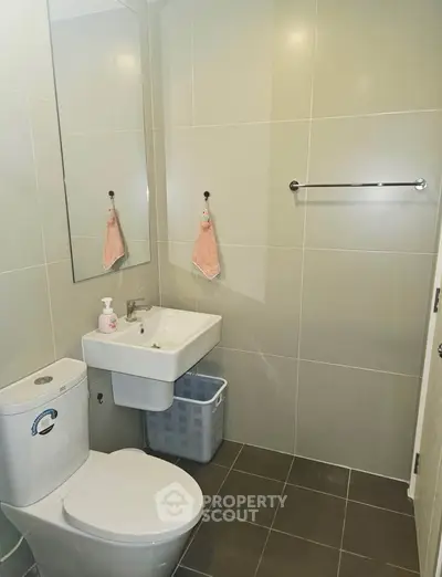 Modern bathroom with sleek tiles and compact fixtures, ideal for urban living.