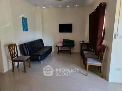 Cozy living room with modern furniture and wall-mounted TV, perfect for relaxation.