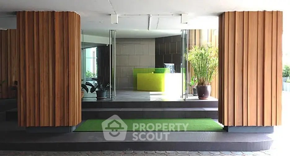 Modern building entrance with stylish wooden panels and green accents