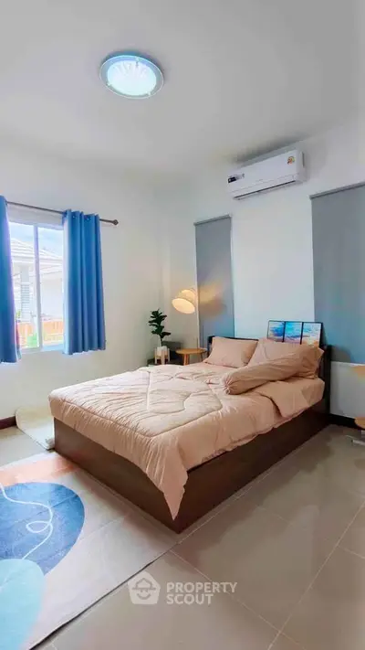 Cozy bedroom with modern decor, featuring a comfortable bed, stylish lighting, and natural light from large windows.
