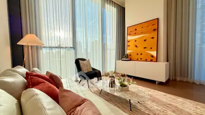 Luxurious living room with modern decor, large windows, and elegant furnishings bathed in natural light.