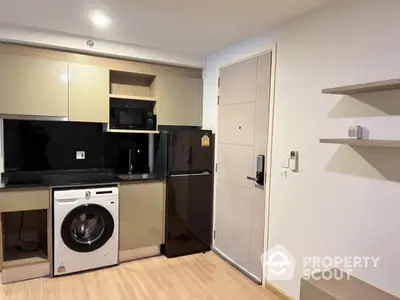 Modern compact kitchen with integrated appliances and sleek cabinetry in a cozy apartment.