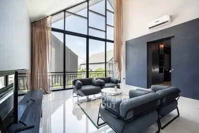 Luxurious modern living room with high ceilings and large windows offering stunning views.