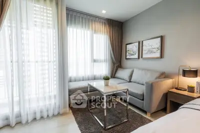 Modern living room with cozy sofa, elegant decor, and large windows for natural light.