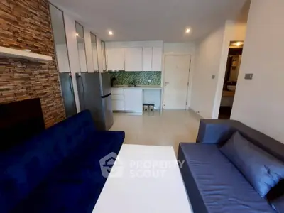 Modern open-layout living room with stylish kitchen and cozy seating area.