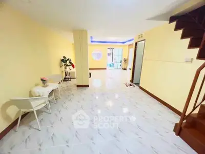 Spacious open-plan living area with modern decor and elegant staircase, perfect for family gatherings.