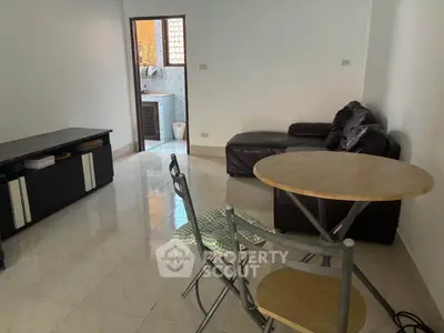 Cozy living room with modern furniture and open access to a small balcony, perfect for urban living.