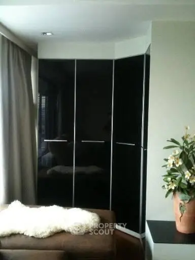 Stylish modern living room with sleek black wardrobe and cozy seating area.
