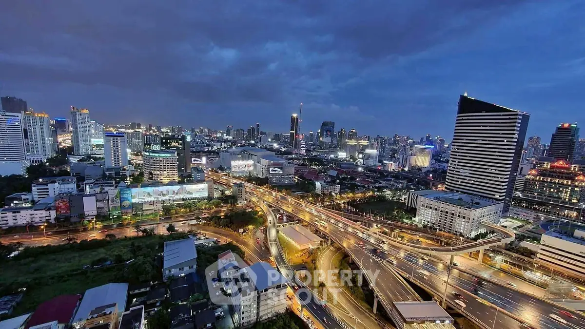 Stunning cityscape view with illuminated skyline and bustling roads at dusk.