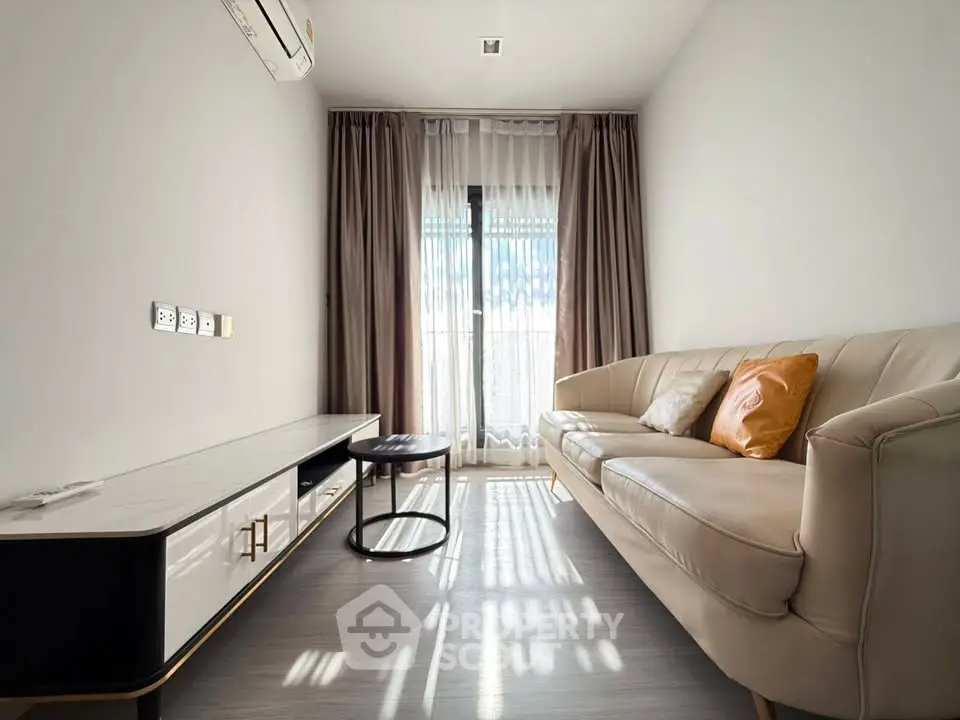Modern living room with elegant sofa and natural light through large window.