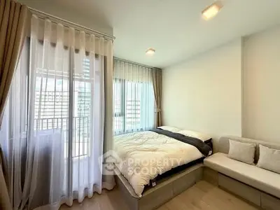Cozy bedroom with modern decor and large windows offering natural light.