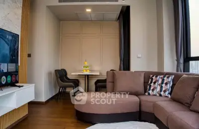 Modern living room with stylish furniture and large windows offering city views.
