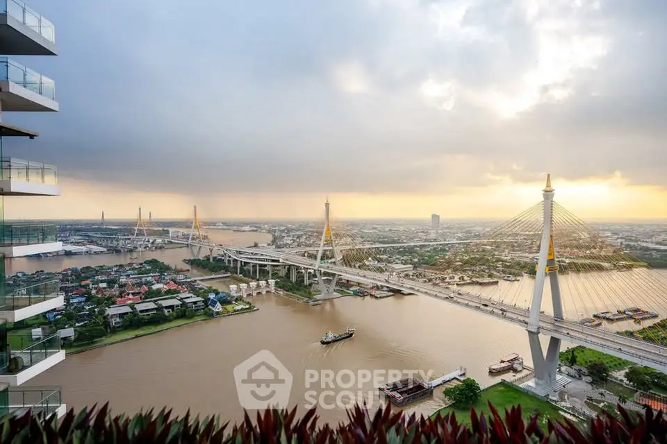 Stunning river view from high-rise balcony with iconic bridge and cityscape at sunset.