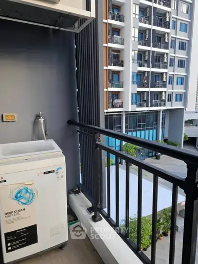 Modern apartment balcony with washing machine and city view
