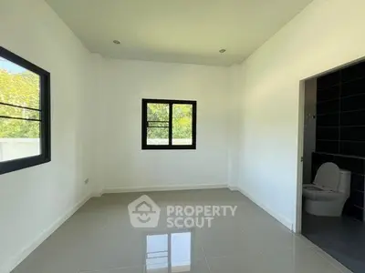Spacious unfurnished room with large windows and attached bathroom, perfect for customization.