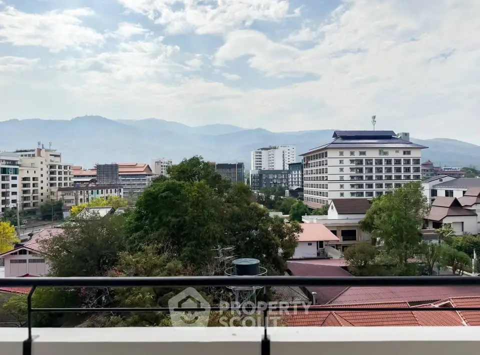 Stunning cityscape view from a balcony overlooking urban skyline and mountains.