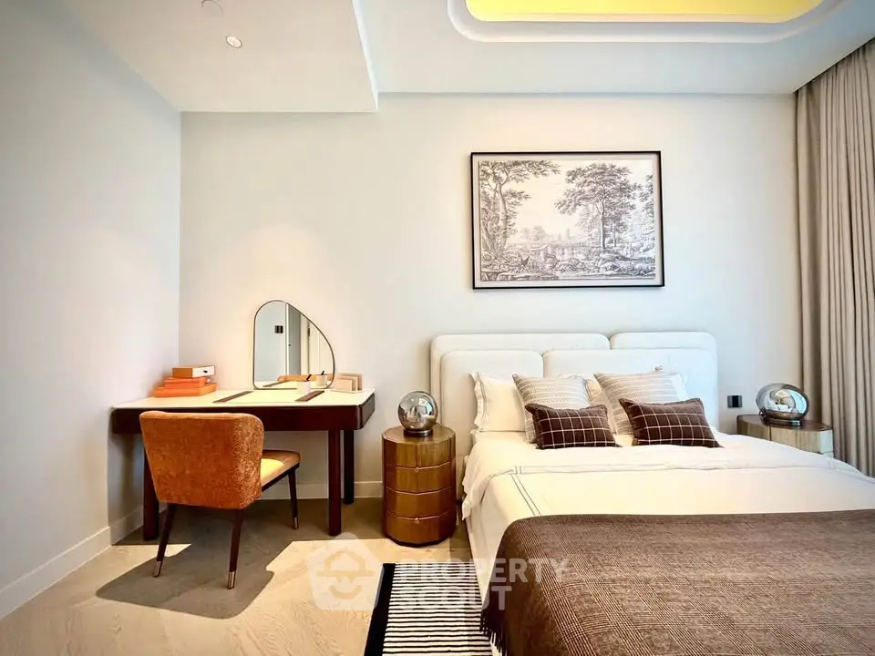 Luxurious bedroom with elegant decor and cozy workspace in modern apartment.