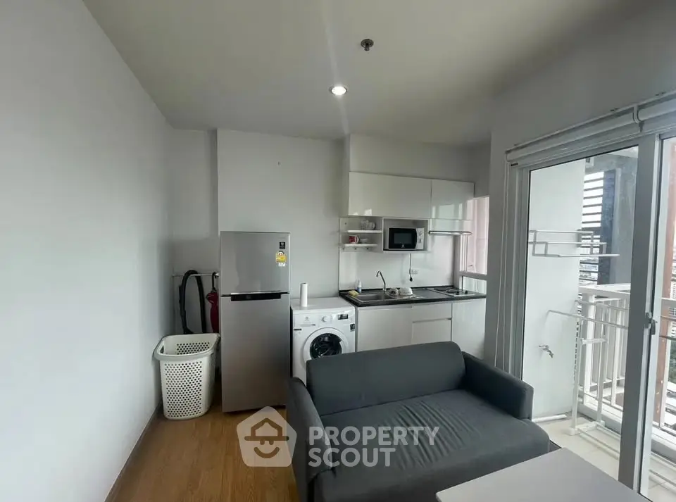 Compact modern kitchen with appliances and balcony access