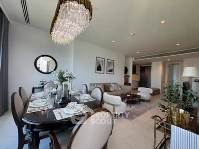 Luxurious open-plan living and dining area with elegant chandelier and modern decor.