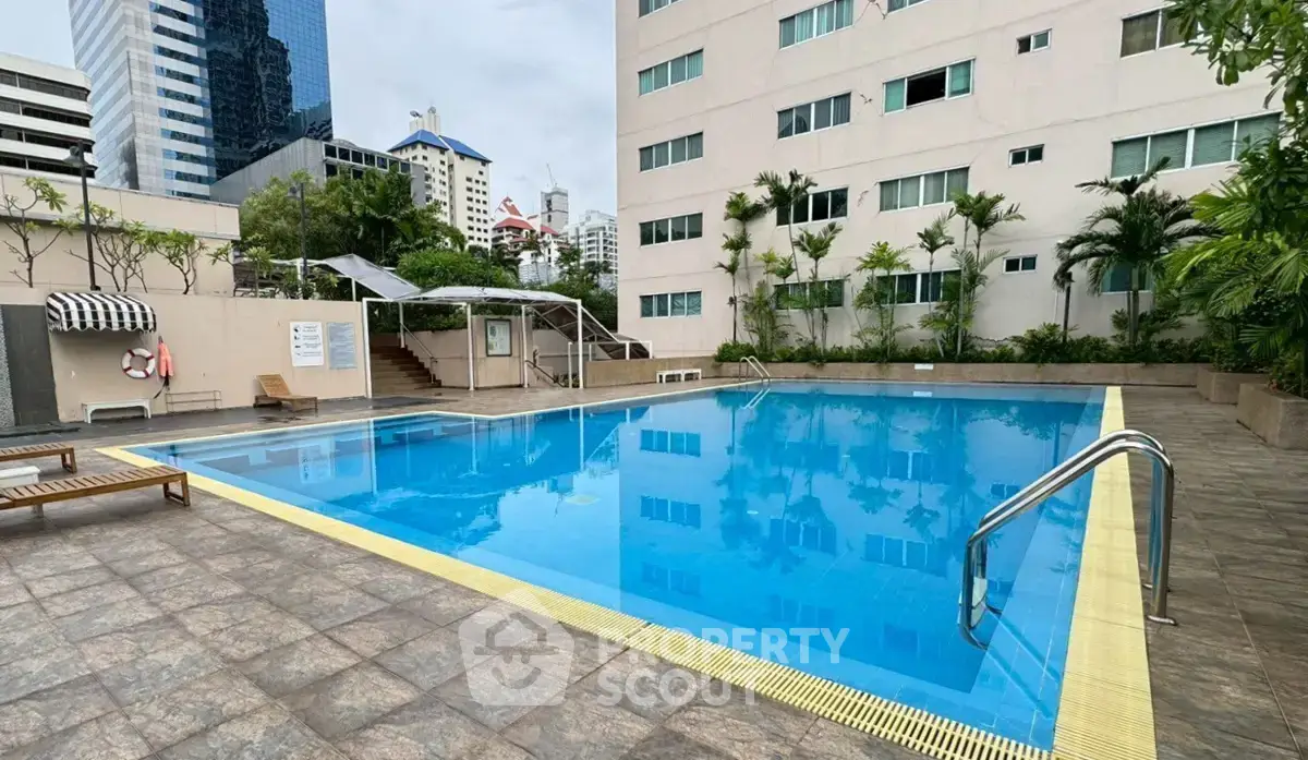 Luxurious apartment complex with a pristine swimming pool and modern architecture.
