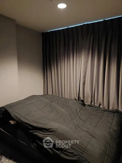 Cozy bedroom with dark curtains and modern bedding